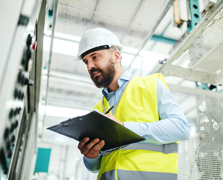 Man checking machine - Certifications and Audits for the Manufacturing Sector​